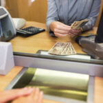 clerk counting cash money at bank office