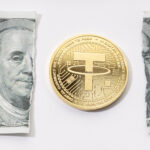 A gold coin placed in the middle of a ripped one-dollar bill.