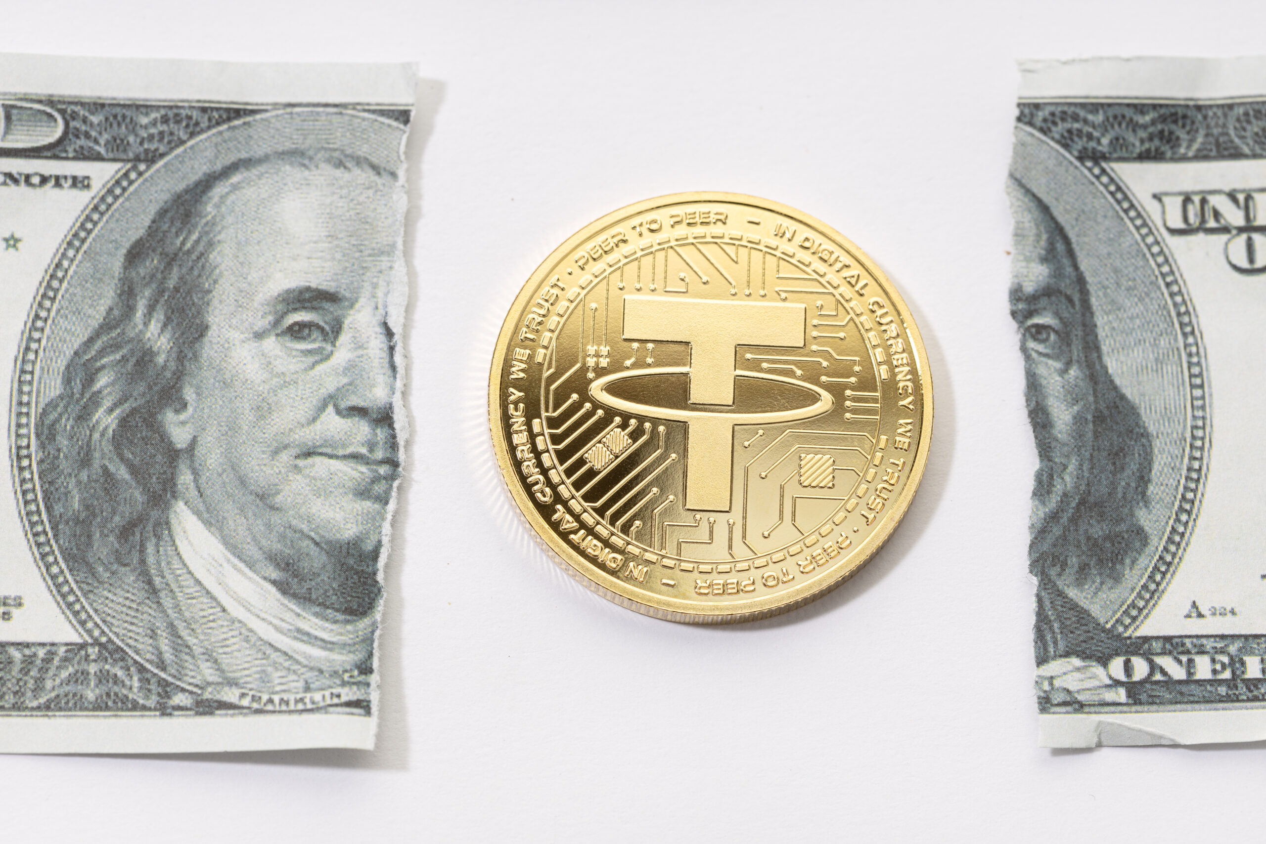 A gold coin placed in the middle of a ripped one-dollar bill.