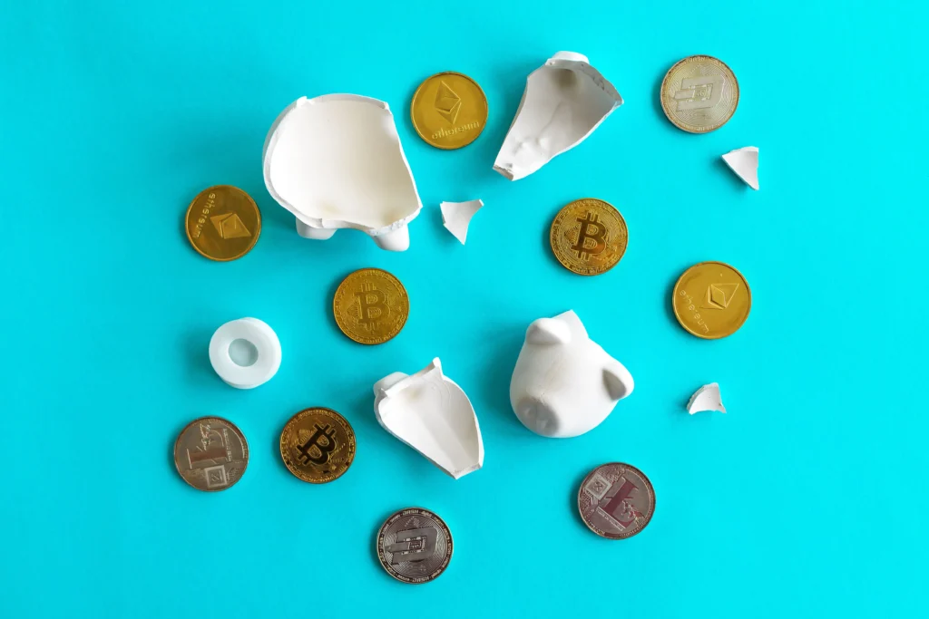 Broken white piggy bank with scattered Bitcoin and Ethereum coins on a blue background, symbolizing financial loss and tech’s playbook in stablecoins